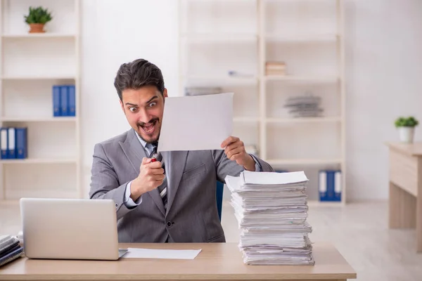 Jovem funcionário masculino infeliz com excesso de trabalho no escritório — Fotografia de Stock