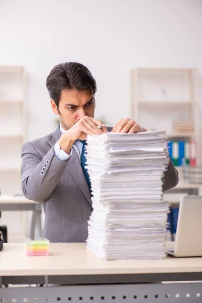 Joven empleado masculino descontento con el trabajo excesivo en la oficina — Foto de Stock