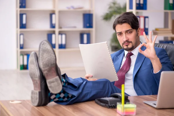 Empleado joven sentado en el lugar de trabajo — Foto de Stock