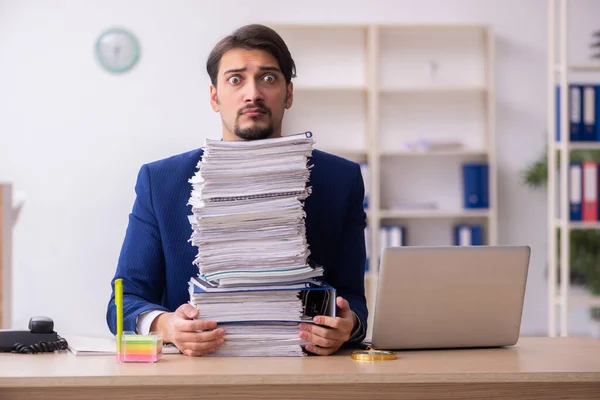 Ung manlig anställd och för mycket arbete på kontoret — Stockfoto