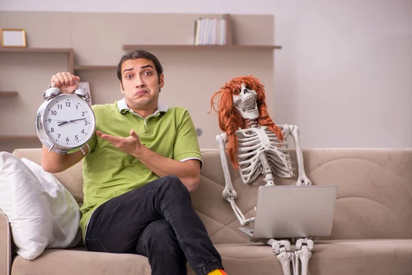 Jeune homme avec squelette féminin dans le concept de gestion du temps — Photo