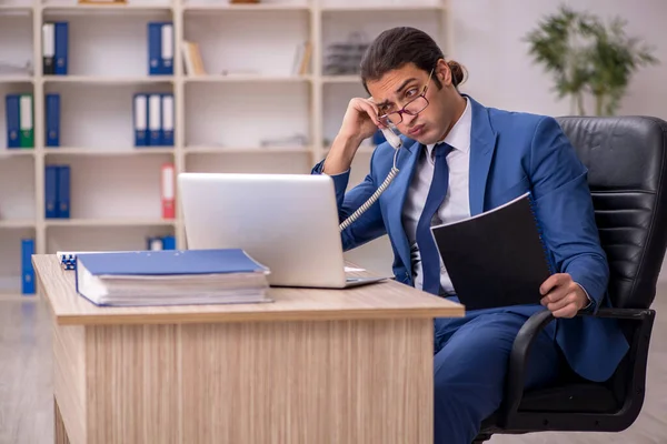 Mladý muž zaměstnanec sedí v kanceláři — Stock fotografie