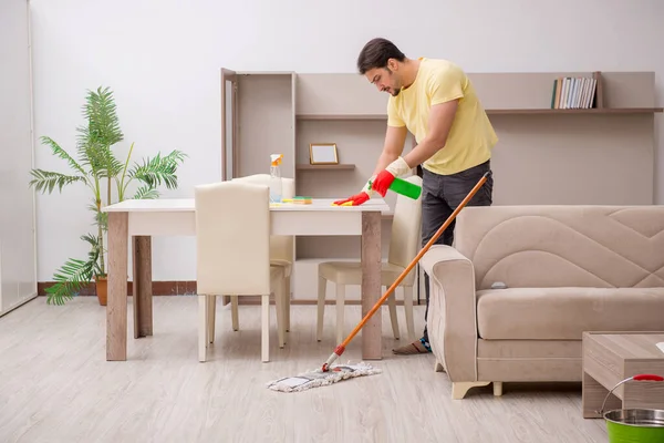 Jonge mannelijke aannemer schoonmaken van het huis — Stockfoto