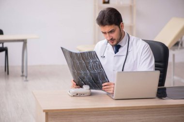 Klinikte çalışan genç bir erkek radyolog.