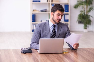 Genç yakışıklı işadamı ofiste çalışıyor.