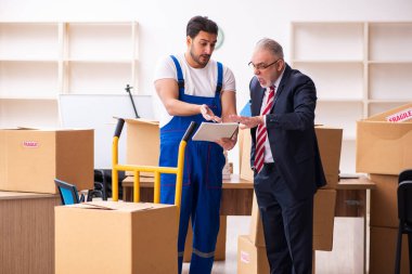 Taşınma konseptinde yaşlı işadamı ve genç müteahhit