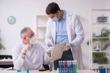 Salgın sırasında laboratuvarda çalışan iki erkek kimyager.