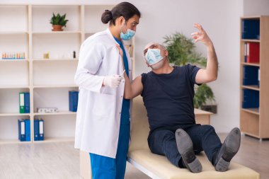 Yaşlı adam covid-19 aşı konseptinde genç doktoru ziyaret ediyor.