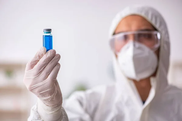 Ung mandlig kemiker, der arbejder på laboratoriet under pandemien - Stock-foto