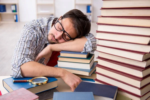 Jeune étudiant et trop de livres en classe — Photo