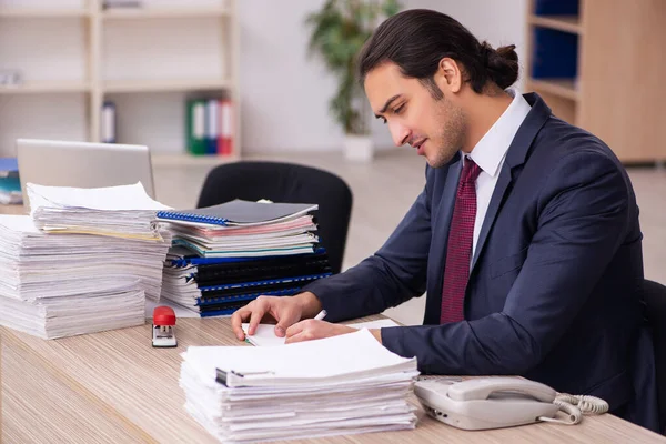 Joven empleado masculino infeliz con el trabajo excesivo — Foto de Stock