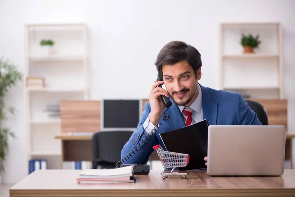 Jonge mannelijke werknemer in e-commerce concept op de werkplek — Stockfoto