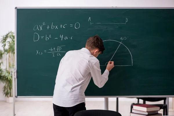 Écolier étudiant la géométrie devant le tableau noir — Photo