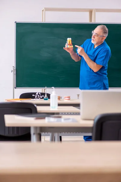 Oude mannelijke tandarts in de klas — Stockfoto