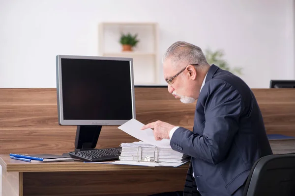 Мужчина в возрасте, сидящий на рабочем месте — стоковое фото