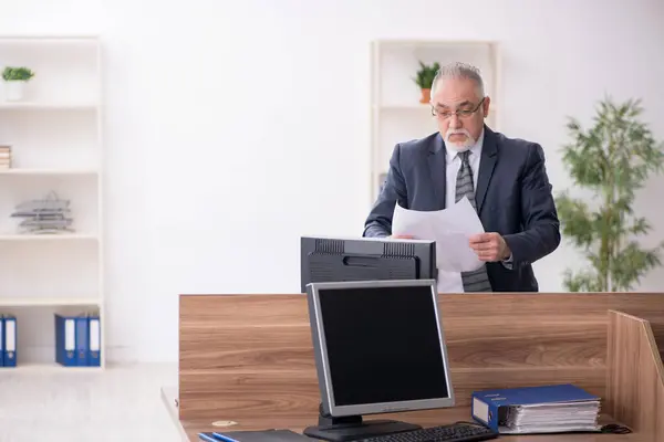 Aged male employee sitting at workplace — Stock Photo, Image