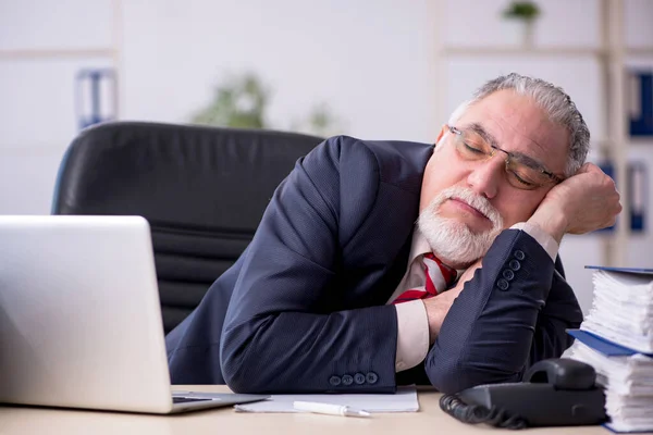 Vecchio dipendente maschile seduto sul posto di lavoro — Foto Stock