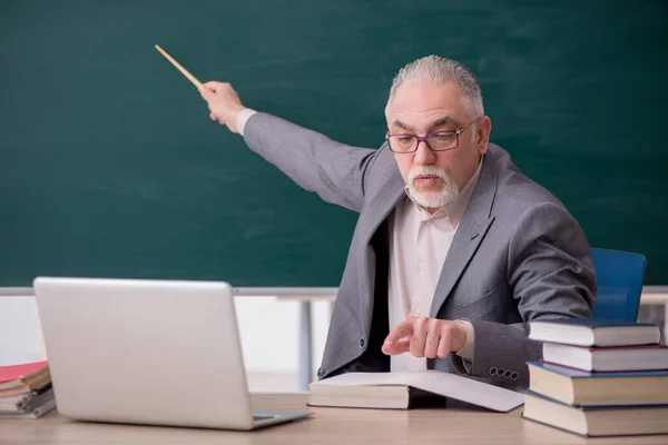 Oude mannelijke leraar voor schoolbord — Stockfoto