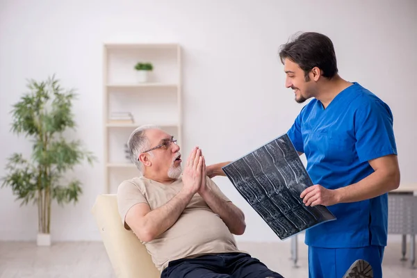 Vecchio paziente maschio visting giovane medico radiologo maschile — Foto Stock