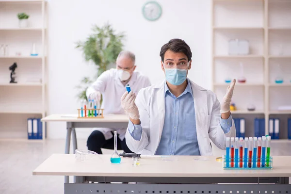 Δύο άνδρες χημικοί που εργάζονται στο εργαστήριο κατά τη διάρκεια πανδημίας — Φωτογραφία Αρχείου