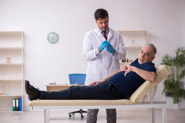 Idős férfi beteg látogató fiatal férfi orvos oltás conce — Stock Fotó
