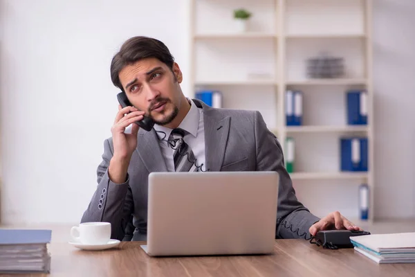 Giovane attraente dipendente maschile seduto sul posto di lavoro — Foto Stock