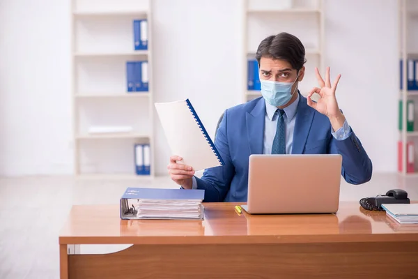 Młody pracownik biznesowy pracujący w biurze podczas pandemii — Zdjęcie stockowe