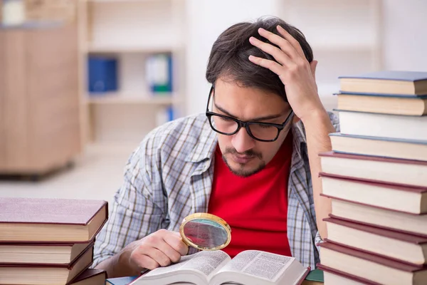 Giovane studente maschio e troppi libri in classe — Foto Stock