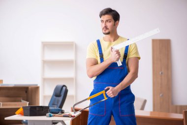 Genç erkek marangoz ofiste çalışıyor.