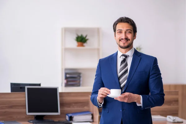 Junge männliche Angestellte trinkt in der Pause Kaffee — Stockfoto