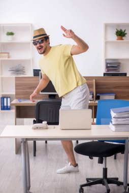 Genç bir erkek işçi iş yerinde geziye hazırlanıyor.