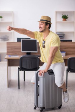 Genç bir erkek işçi iş yerinde geziye hazırlanıyor.