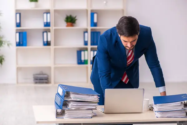 Joven empleado masculino descontento con el trabajo excesivo en la oficina —  Fotos de Stock