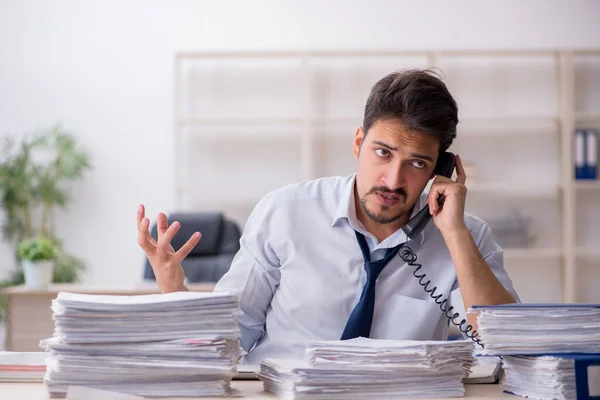 Giovane dipendente maschio infelice con un lavoro eccessivo in ufficio — Foto Stock