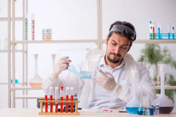 Mladý muž chemik extrémně unavený v laboratoři — Stock fotografie