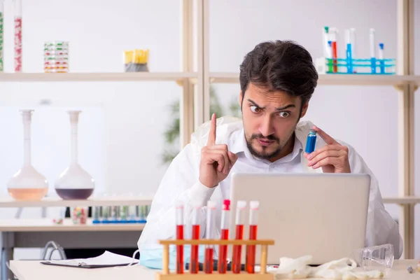 Ung manlig kemist sitter vid datorn på labbet — Stockfoto