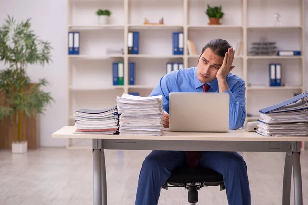 Joven empleado masculino infeliz con el trabajo excesivo —  Fotos de Stock