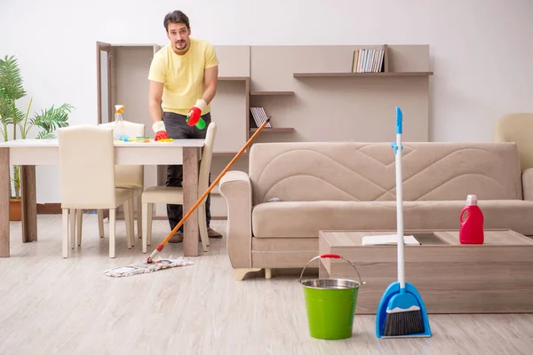 Joven contratista masculino limpiando la casa — Foto de Stock