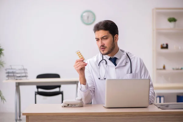 Junger Arzt mit Tabletten in der Klinik — Stockfoto