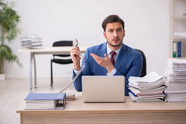 Junge männliche Mitarbeiter und zu viel Arbeit im Büro — Stockfoto