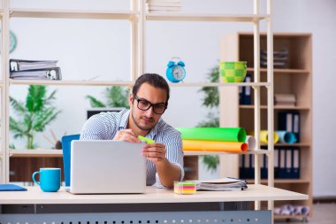 Ofiste çalışan genç bir erkek.