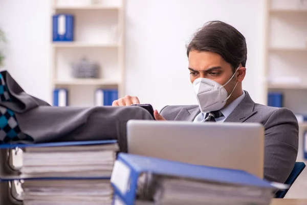 Joven trabajador masculino que trabaja en el lugar de trabajo durante una pandemia — Foto de Stock