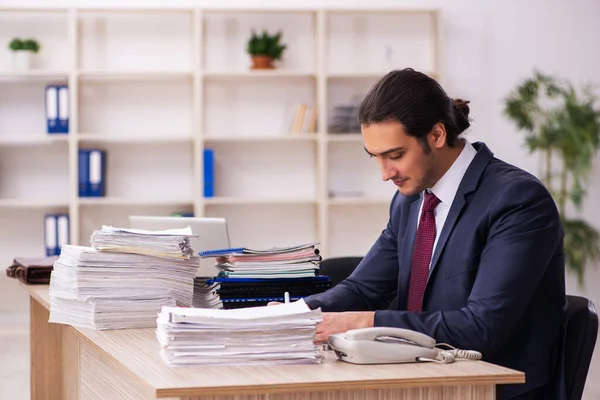 Jonge mannelijke werknemer ongelukkig met overmatig werk — Stockfoto