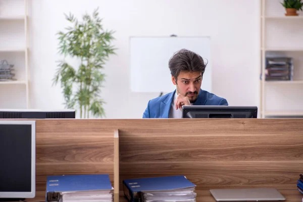 Mladý muž zaměstnanec sedí na pracovišti — Stock fotografie