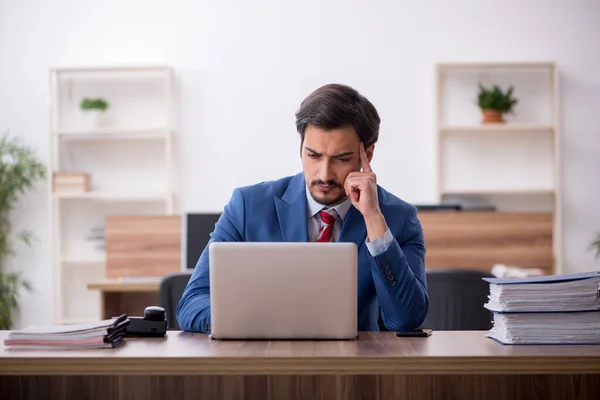 Junge männliche Mitarbeiter sitzen am Arbeitsplatz — Stockfoto