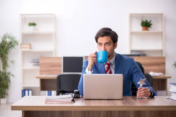 Jeune employé masculin avec un prix étoile sur le lieu de travail — Photo