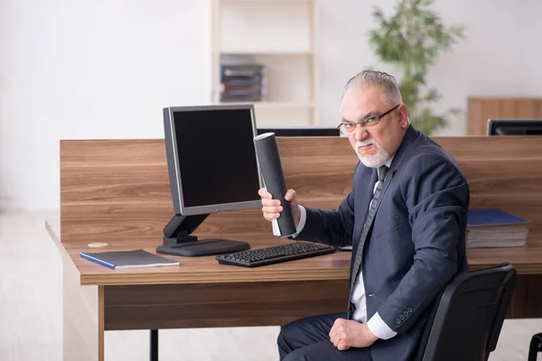 Věk muž zaměstnanec sedí na pracovišti — Stock fotografie