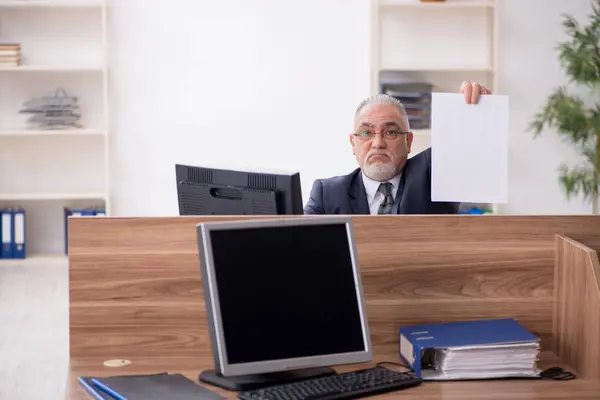 Hombre anciano empleado sentado en el lugar de trabajo —  Fotos de Stock