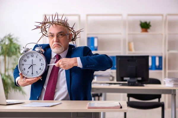 Velho empregado masculino vestindo grinalda espinhosa no conceito de gerenciamento de tempo — Fotografia de Stock