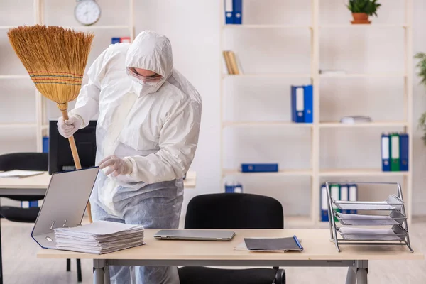 Empreiteiro velho limpando o escritório segurando vassoura — Fotografia de Stock